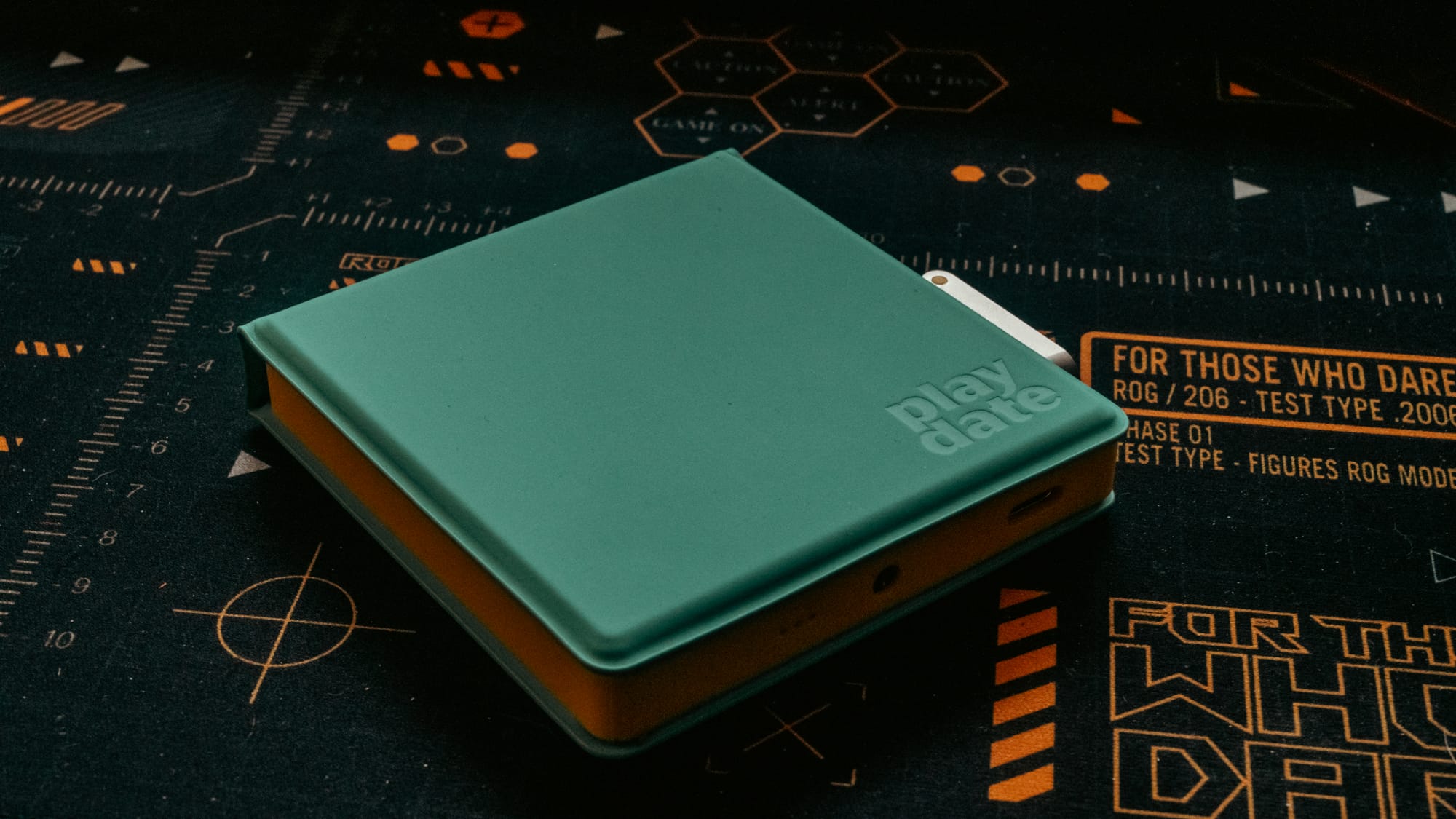 The teal playdate case set against a black mat.